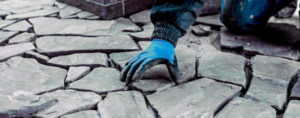 Muž spáruje venkovní dlažbu